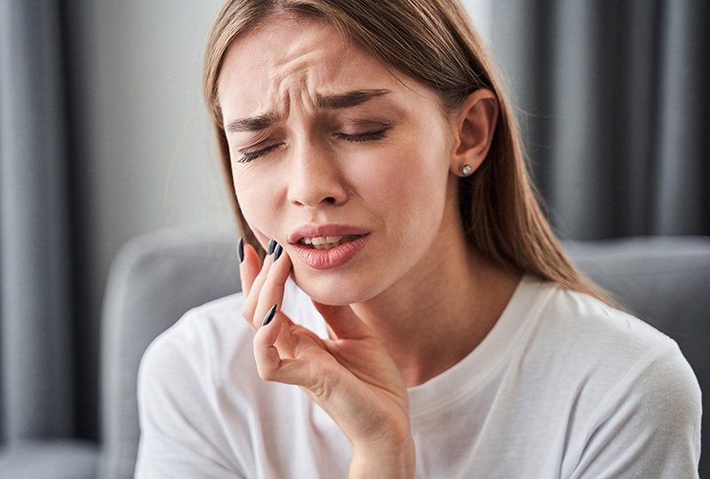 Woman with hand on face, appearing distressed or overwhelmed.
